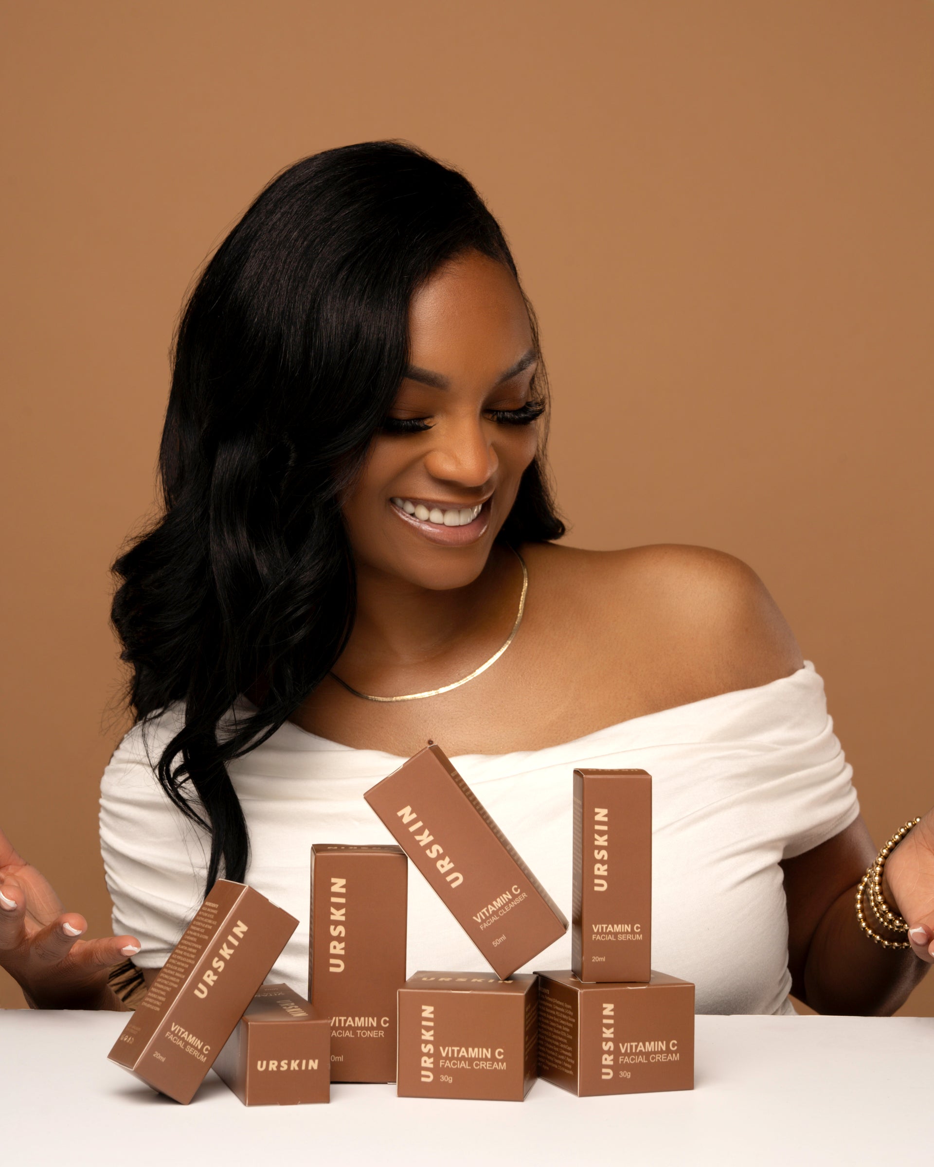 A woman with melanin-rich skin holding URSKIN Vitamin C packaging